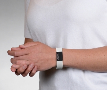 Person wearing on wrist the Performance silicone Medical ID bracelet with a white band and a black colored rectangular emblem