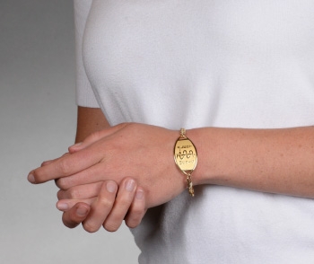 A person 10 karat gold classic large embossed medical ID bracelet with oval MedicAlert emblem