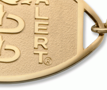 A close-up of a 10 karat gold classic large embossed medical ID bracelet with oval MedicAlert emblem