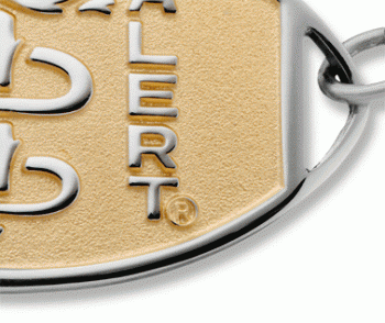 A close-up view of two tone classic large embossed silver medical ID bracelet with gold oval MedicAlert emblem and logo