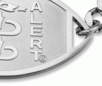 A close-up view of the sterling silver classic embossed medical ID bracelet with oval MedicAlert emblem and logo
