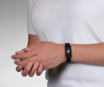 A person wearing a black quilted sport silicone medical ID bracelet with rectangle MedicAlert emblem and logo