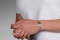 A person wearing the 10 karat gold classic embossed medical ID bracelet with oval emblem and logo