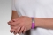 Person wearing a violet silicone medical ID bracelet with rectangle MedicAlert emblem
