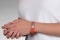 Person wearing a red silicone medical ID bracelet with rectangle MedicAlert emblem 
