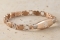 A close-up of a rose gold medical ID Bracelet with rectangular interlocking and heart shaped links, oval MedicAlert emblem in silver