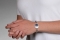 A person wearing a blue fabric medical ID bracelet with infinity symbol, oval MedicAlert emblem in blue